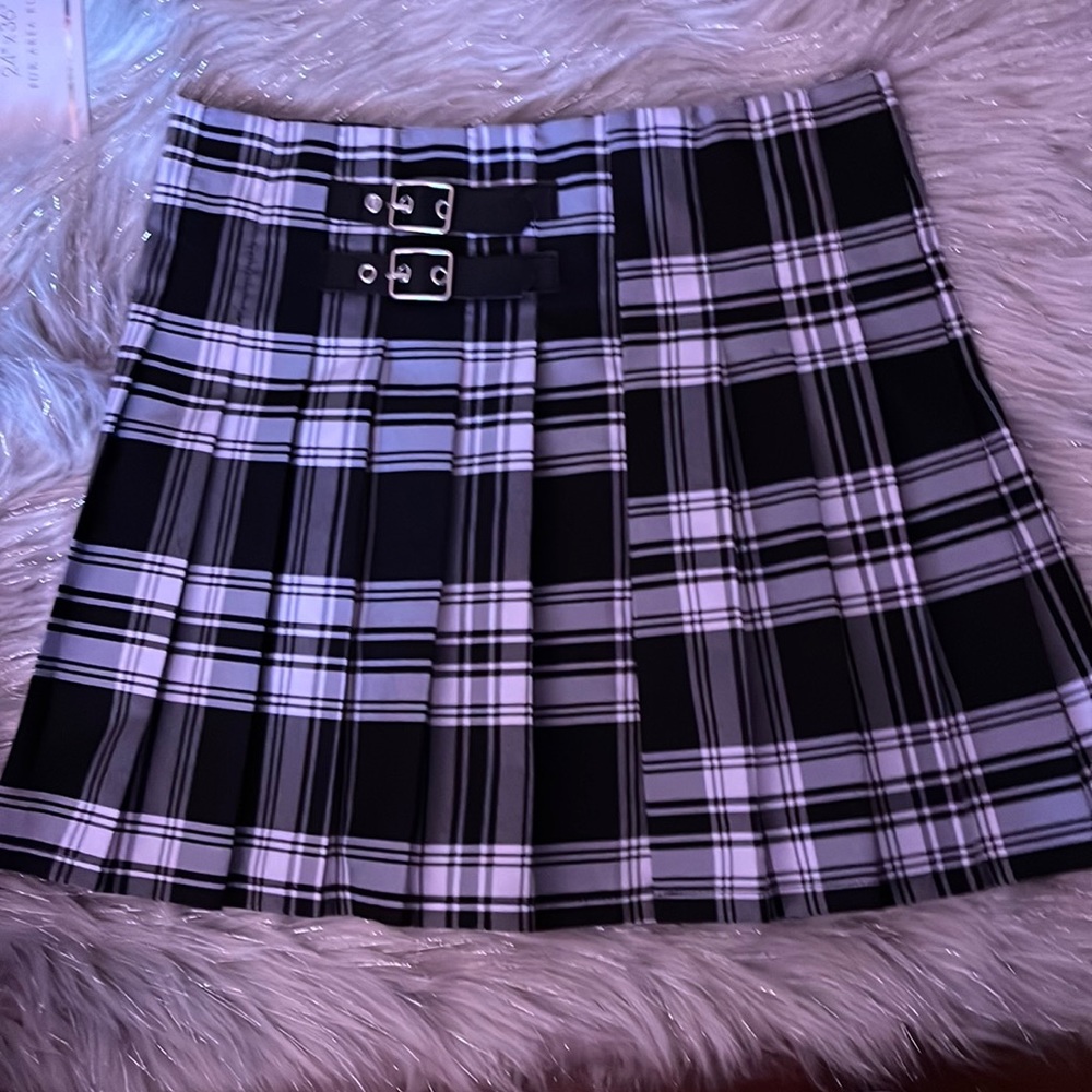 Medium size pleated skirt with buckle detail in the front